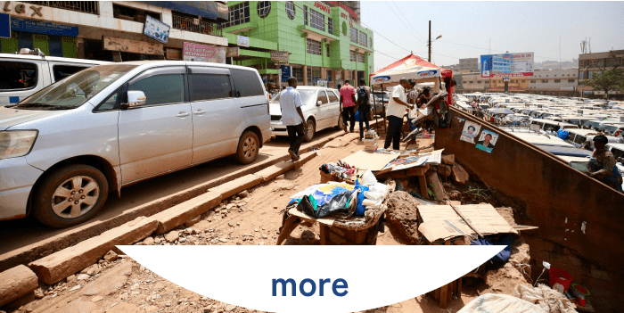 道路脇に露店が並び、商品が地面や台に置かれている街の風景