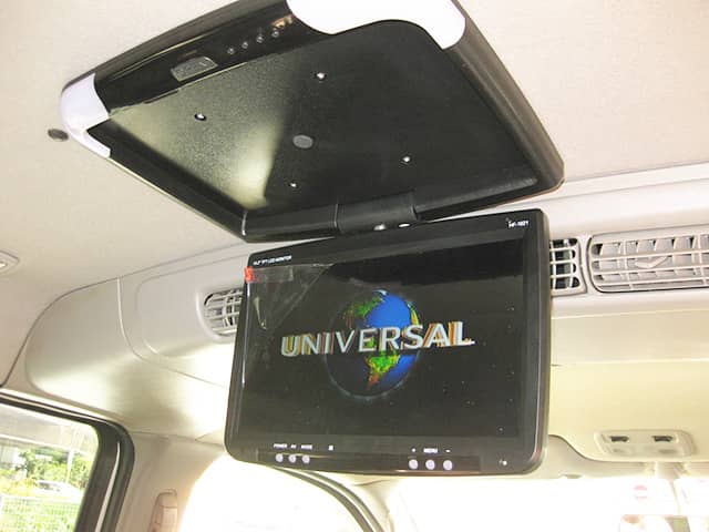 車内天井に設置されたフリップダウンモニターにUNIVERSALのロゴが表示されている。