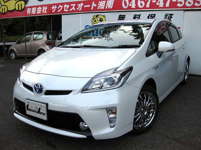 光沢のあるボディと社外ホイールが特徴の白いプリウス。