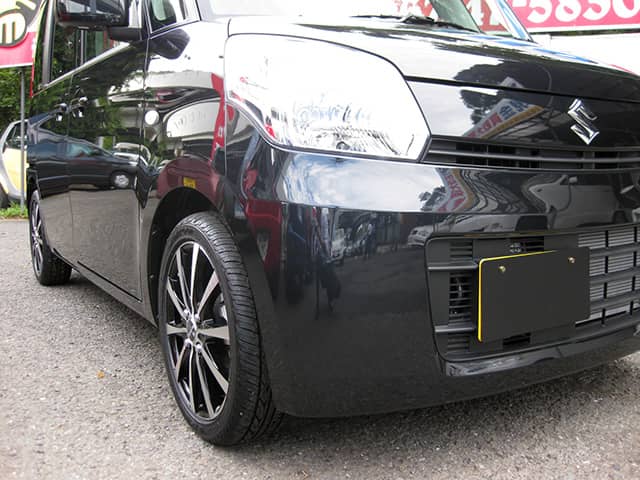 光沢のあるブラックボディとアルミホイールが印象的な軽自動車。