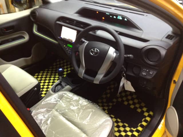 チェッカーフラッグ柄のフロアマットが敷かれたトヨタ車の車内。