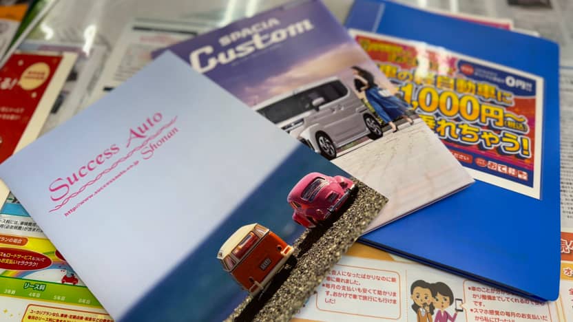 自動車のパンフレットやカタログがテーブルに並べられている写真