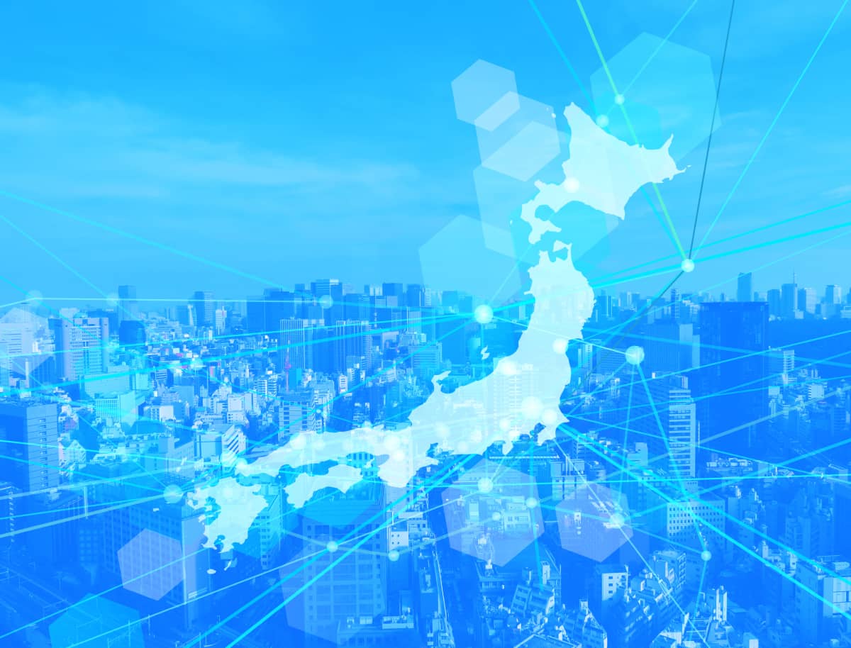 日本地図と都市のビル群を重ね、ネットワーク線が交差するイメージ画像